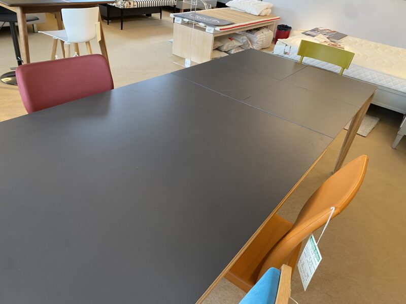 Table BUZZ de DASRAS dessus céramique piétement chêne massif avec 2 allonges en bout de 50 cm en céramique aux meubles chalon 07500 moderne et contemporaine
