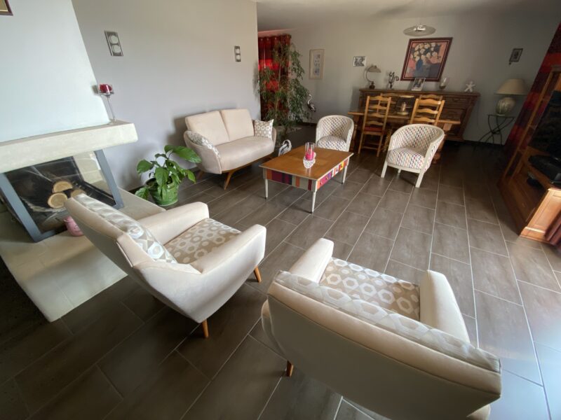 Fauteuil grand confort tissus clair pieds bois laqué